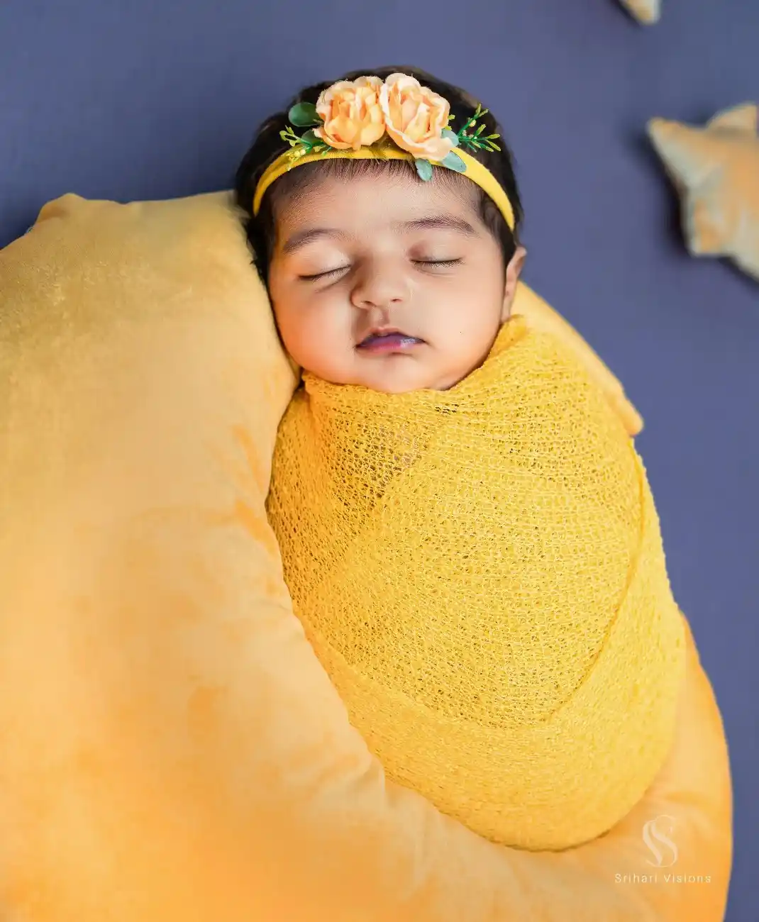 Newborn baby wrapped in a knitted blanket during photoshoot
