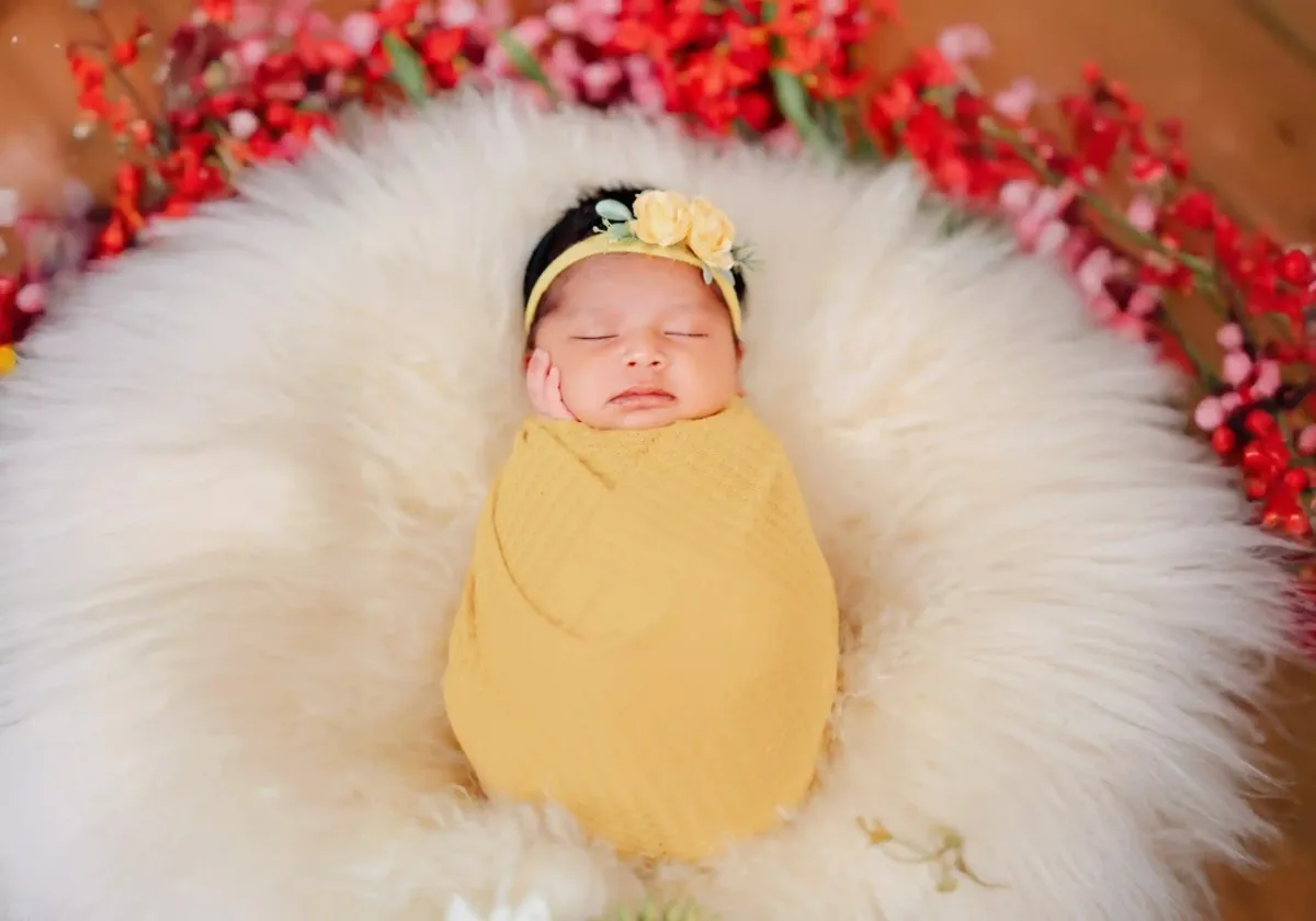 Newborn baby wrapped in a soft blanket during photoshoot
